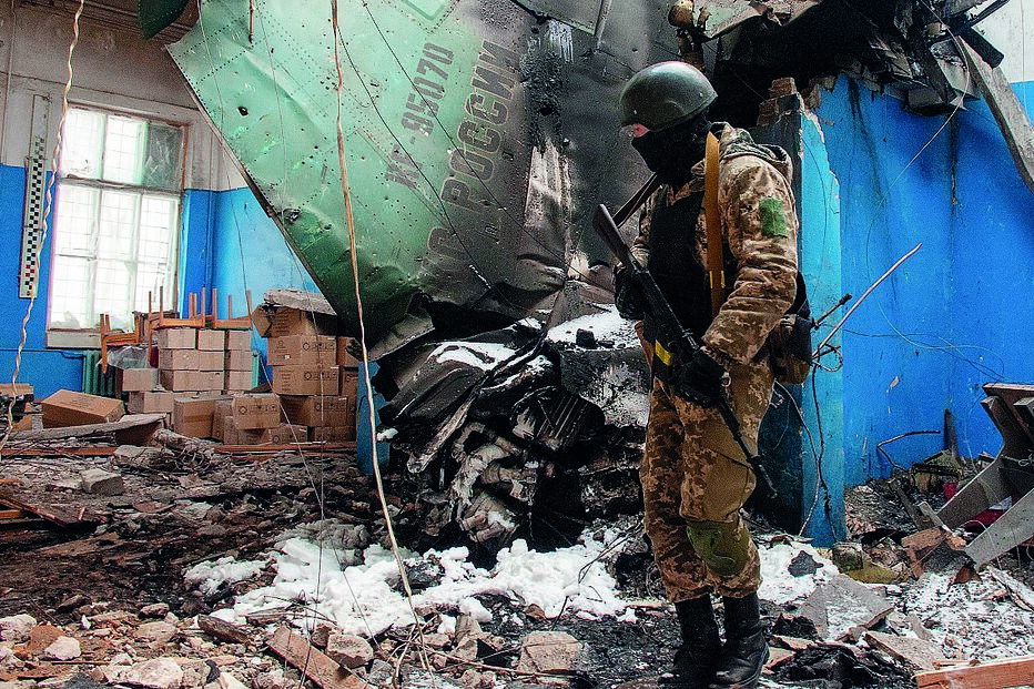 Militar ucraniano junto aos destroços de um  caça-bombardeiro russo Su-34, abatido na cidade de Kharkiv