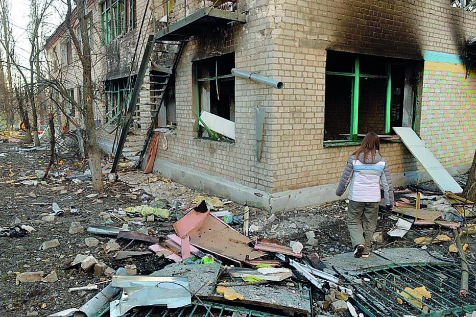 Destruição. Rapariga caminha junto a jardim de infância atingido pelas bombas em Kharkiv.  