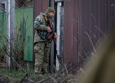 Um membro de serviço ucraniano verifica a área na aldeia de Kozarovychi
