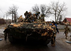 Soldados ucranianos são fotografados no seu veículo militar, no meio da invasão russa na Ucrânia em Bucha, na região de Kyiv