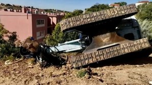 Máquina de obras com várias toneladas cai e destrói muro de casa em Lisboa