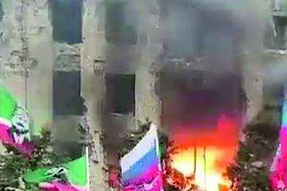 Elementos do Kadyrovtsy em frente a um edifício em ruínas, na Ucrânia