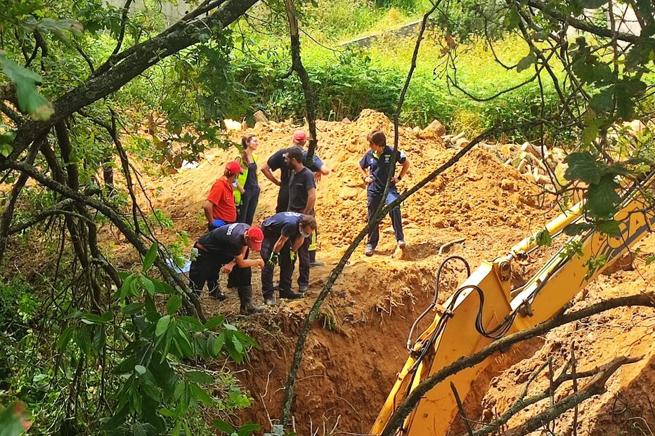Máquina retroescavadora a abrir um túnel até ao ponto onde a vítima está presa