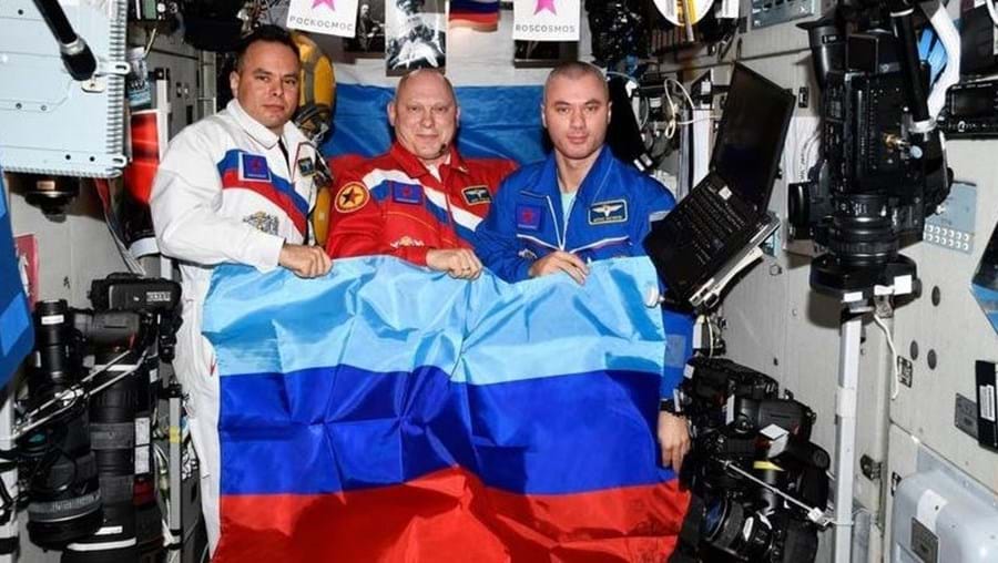 Fotografias dos astronautas Oleg Artémiev, Denis Matvéïev e Sergei Korsakov, agitando as bandeiras das duas "repúblicas" do leste da Ucrânia