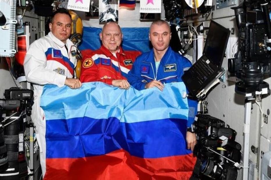 Fotografias dos astronautas Oleg Artémiev, Denis Matvéïev e Sergei Korsakov, agitando as bandeiras das duas 