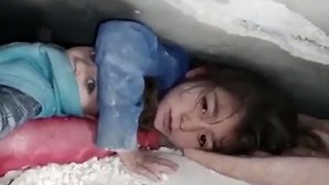 Criança protege irmão mais novo enquanto esperam para ser salvos dos escombros dos sismos na Turquia 