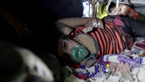 Socorristas conversam com menina presa nos escombros na Síria