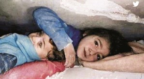Criança protege irmão mais novo enquanto esperam para ser salvos dos escombros dos sismos na Turquia