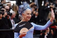 A atriz surgiu de cabelo e vestido azuis, com um leque com a mensagem 