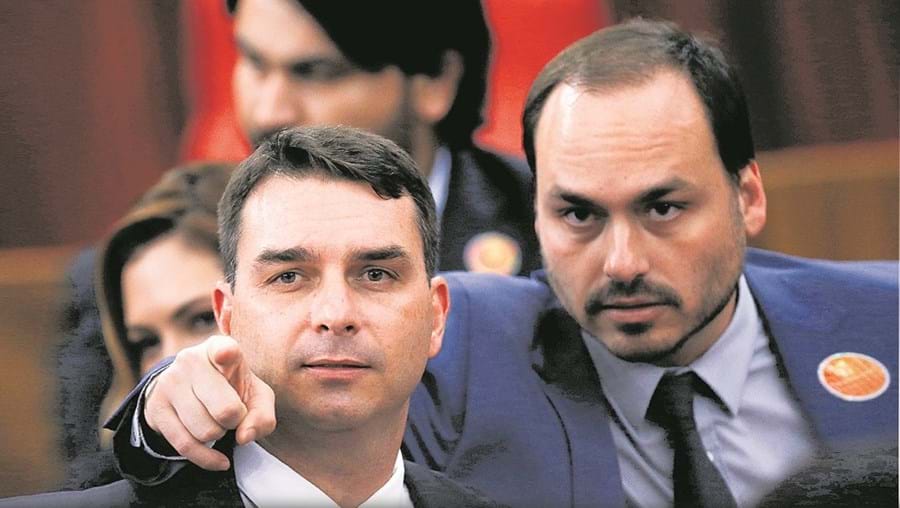 Carlos Bolsonaro (à direita) terá ‘copiado’ o esquema ilegal alegadamente usado pelo irmão Flávio no Parlamento do Rio