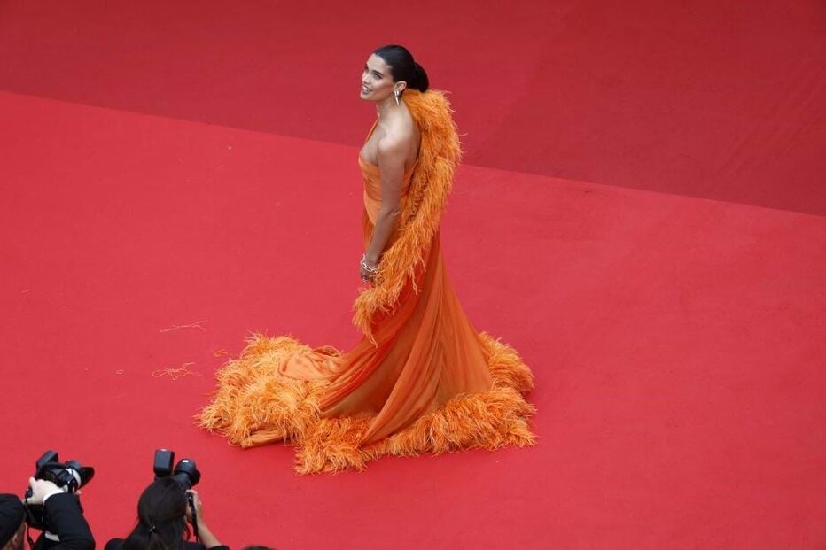 A modelo optou por um vestido em tons de laranja 