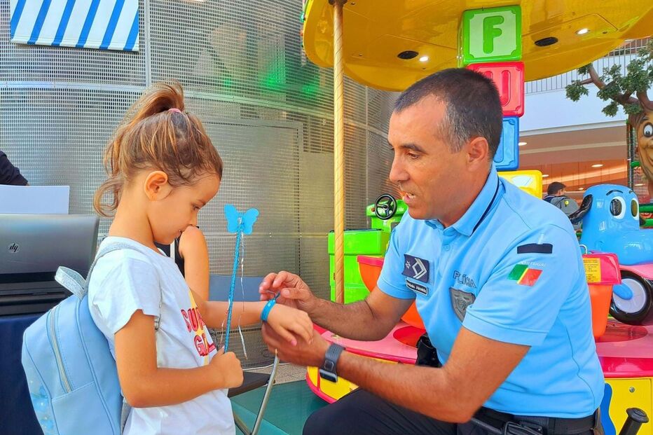 Agente da PSP coloca pulseira do programa 