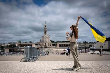 Jovem com bandeira da Ucrânia em Fátima