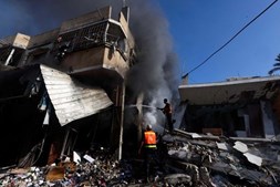 Bombeiros tentam apagar incêndio em edifício após ataque israelita na Faixa de Gaza 