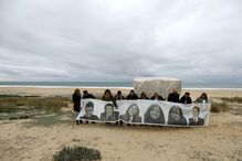 Familiares das seis vítimas junto ao memorial, na praia do Meco, com uma tarja com as imagens das vítimas