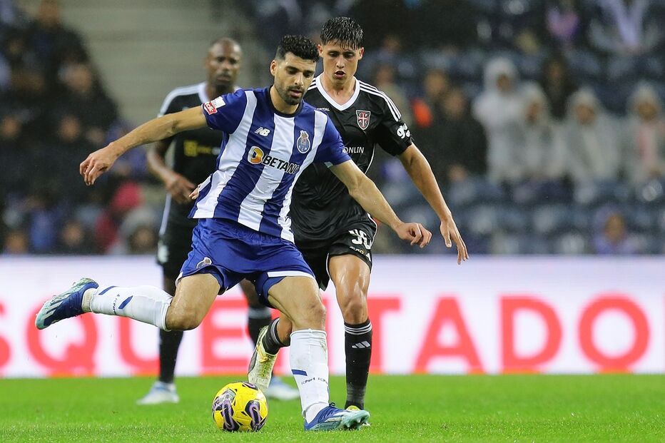 Taremi protege a bola perante a pressão de Samuel Justo