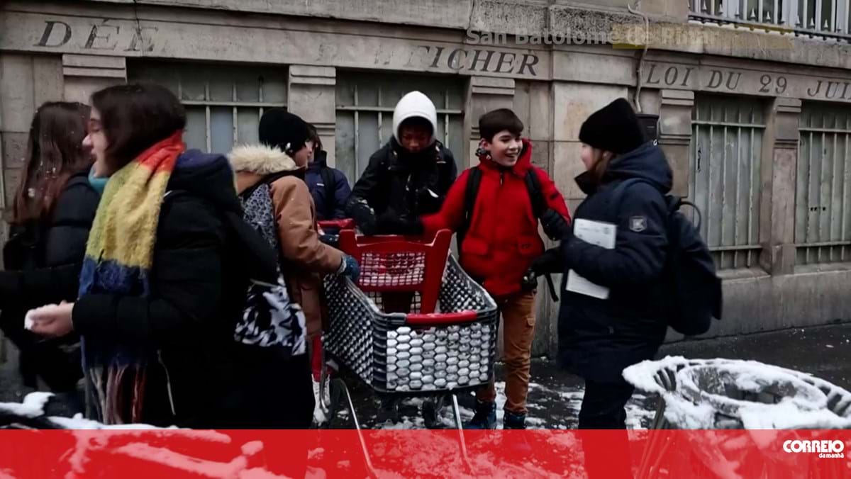 Crianças e turistas desfrutam da neve em Paris