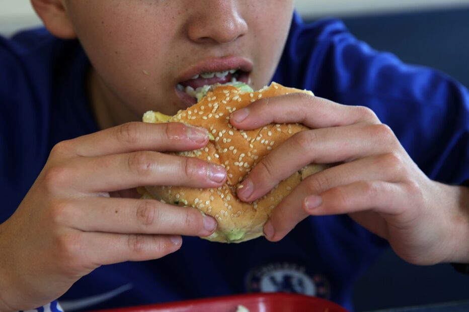 Criança a comer hambúrguer