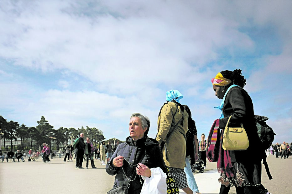 Peregrina reza o terço enquanto percorre de joelhos a passadeira que vai dar à capelinha