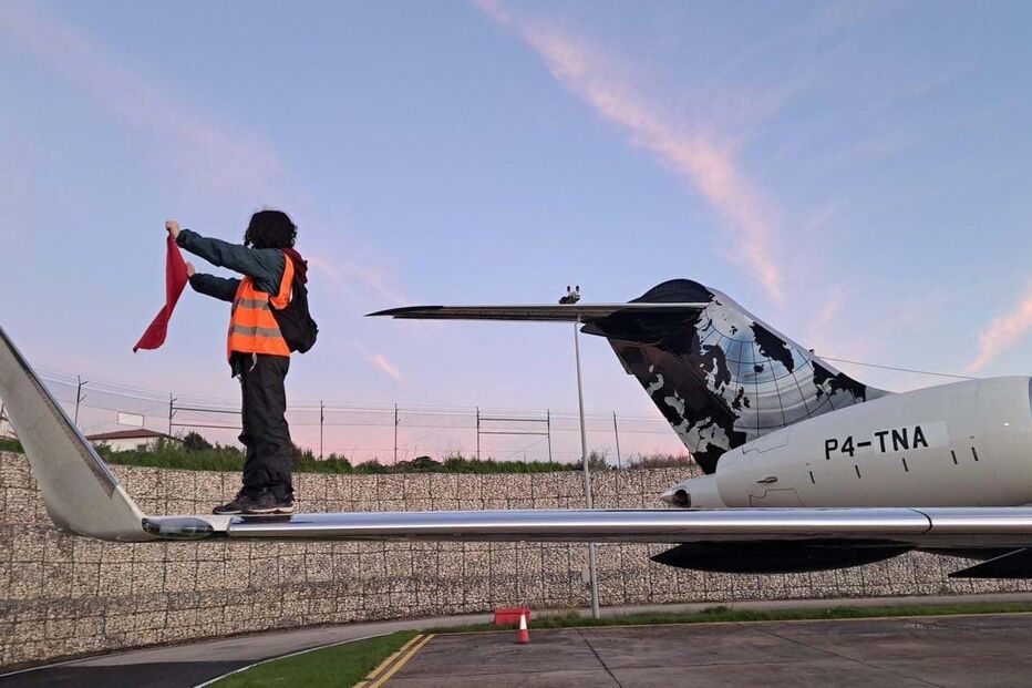 Ativista na asa do avião durante o protesto