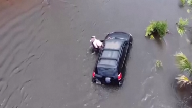 Imagens de drone mostram resgate de uma pessoa presa num veículo após tempestade Debby