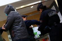 Homem a esconder a cara à chegada do Tribunal Penal de Vaucluse