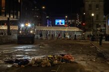 Presidente Donald Trump é visto no ecrã enquanto trabalhadores limpam as malas e outros itens deixados à porta da Capital One Arena