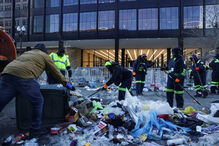  Trabalhadores limpam malas e outros itens deixados à porta da Capital One Arena na inauguração do segundo mandato de Donald Trump