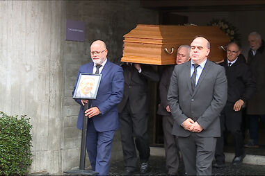 Urna com o corpo a sair da igreja