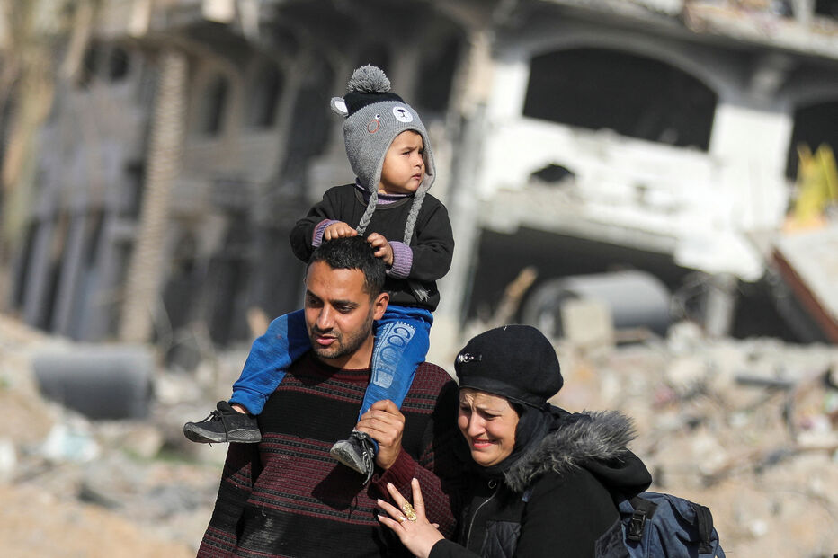 Palestinianos deslocados passam pelos escombros para regressar às suas casas em Gaza, após início de cessar-fogo