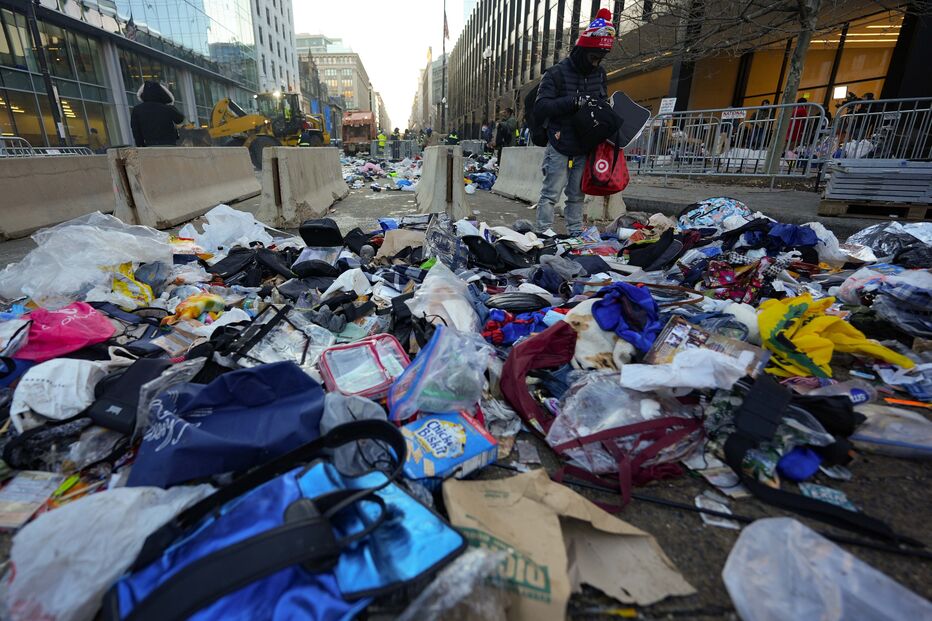 Homem vasculha pelos itens deixados à porta da Capital One Arena na inauguração do segundo mandato de Donald Trump