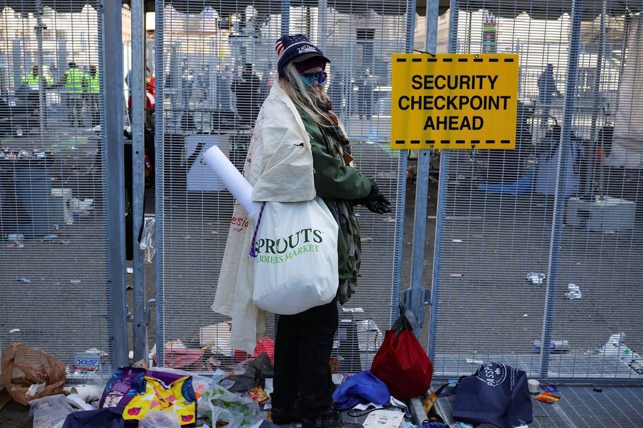 Pessoa junto de malas e outros itens deixados à porta da Capital One Arena na inauguração do segundo mandato de Donald Trump
