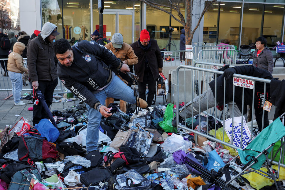 Pessoas vasculham pelos itens deixados à porta da Capital One Arena na inauguração do segundo mandato de Donald Trump