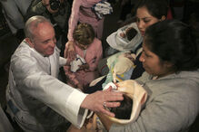 Jorge Mario Bergoglio toca em bebé após celebrar missa em Buenos Aires, 2011