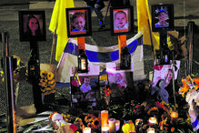 Flores e velas num memorial im provisado à família Bibas