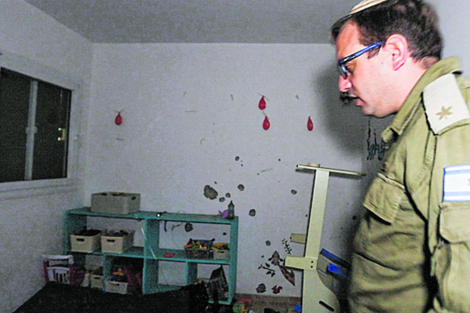 Major Roni Kaplan mostra o quarto de Kfir e Ariel, onde há brinquedos e marcas dos disparos na parede
