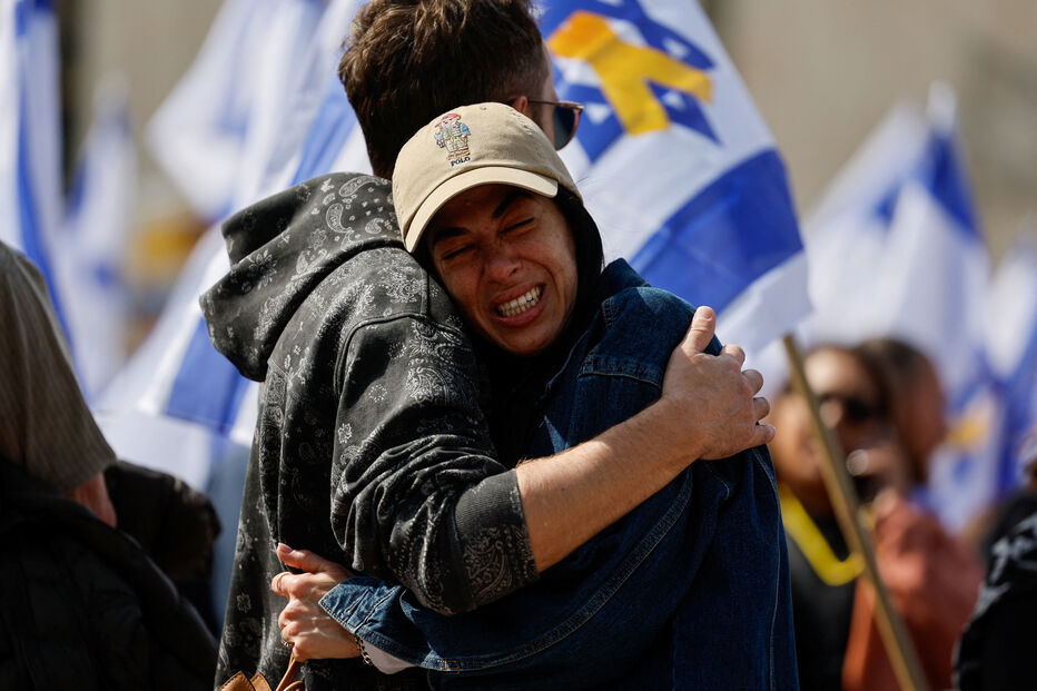Várias pessoas reagem à entrega dos corpos dos reféns israelitas