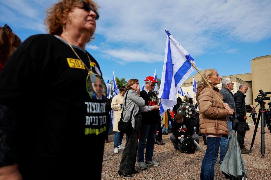 Várias pessoas reagem à entrega dos corpos dos reféns israelitas