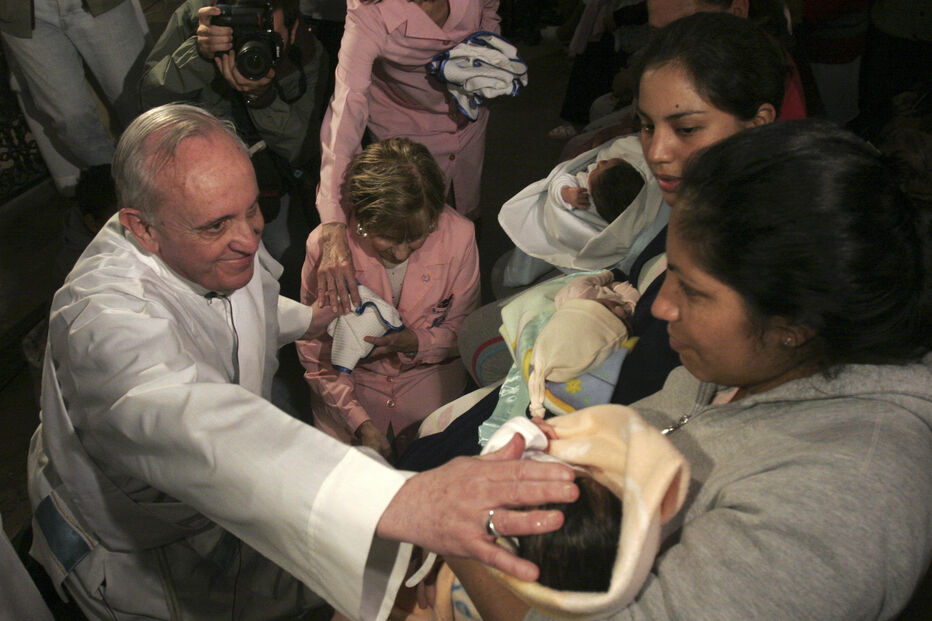 Jorge Mario Bergoglio toca em bebé após celebrar missa em Buenos Aires, 2011