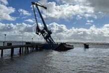 Mau tempo fez uma barcaça grua adornar e semi afundar no cais da Matinha, no rio Tejo, em Lisboa