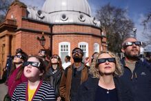 Entusiastas usam óculos de proteção para observar eclipse solar parcial no Observatório de Greenwich em Londres, no Reino Unido