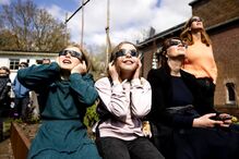 Entusiastas usam óculos de proteção para observar eclipse solar parcial em Utrecht, nos Países Baixos