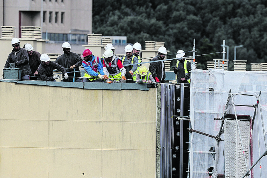 Lisboa. Trabalhadores tentam puxar parte de uma estrutura de andaimes que desabou devido à tempestade ‘Martinho’