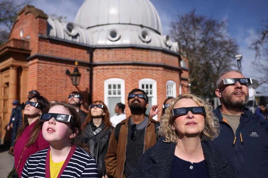 Entusiastas usam óculos de proteção para observar eclipse solar parcial no Observatório de Greenwich em Londres, no Reino Unido