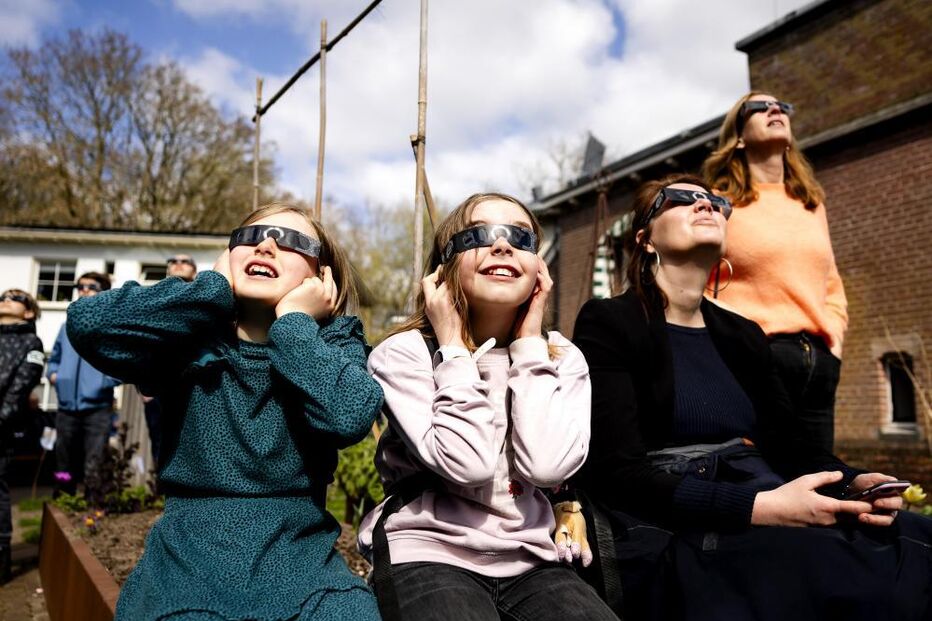 Entusiastas usam óculos de proteção para observar eclipse solar parcial em Utrecht, nos Países Baixos
