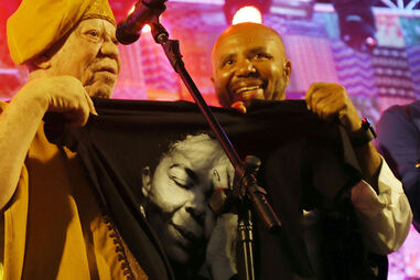 Djo da Silva com o cantor Salif Keita, segurando uma camisola com a fotografia de Cesária Évora