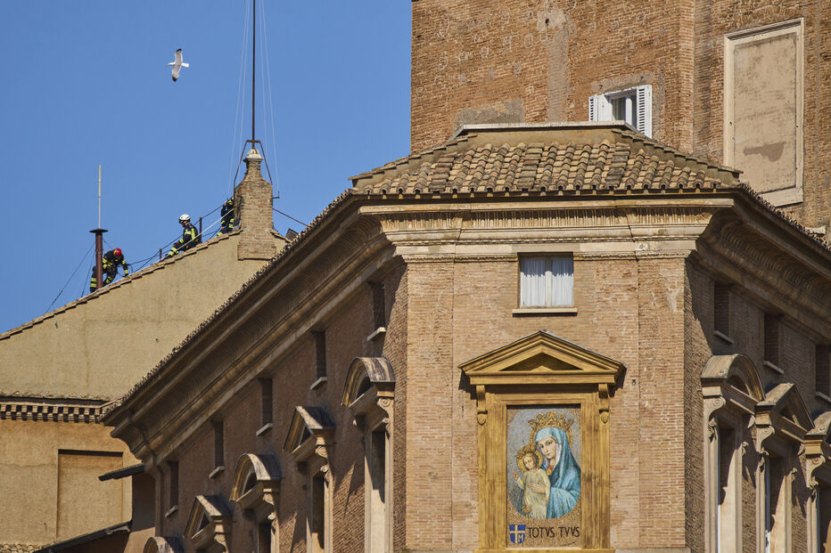 Bombeiros colocam a chaminé no telhado da Capela Sistina