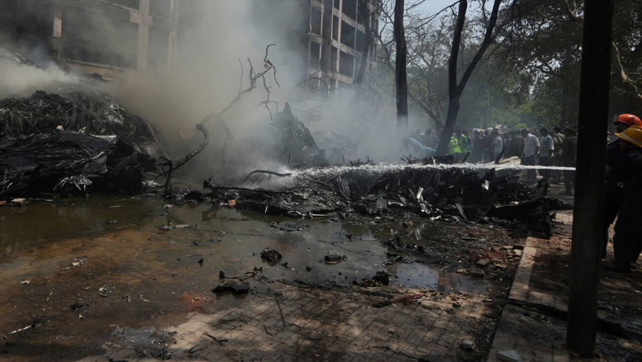 Destroços fumegantes após incidente com multidão e bombeiros no local