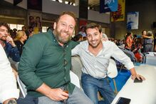Dois homens sorriem para a câmara num evento