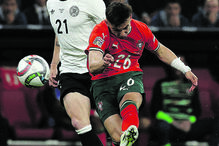 Dois jogadores de futebol competem pela bola num jogo